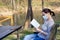 Woman with a protective mask on face reading a book.