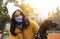 Woman in protective mask with German Shorthaired Pointer outdoors. Walking dog during COVID-19 pandemic