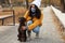 Woman in protective mask with German Shorthaired Pointer in park. Walking dog during COVID-19 pandemic