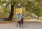 Woman in protective mask with German Shorthaired Pointer in park. Walking dog during COVID-19 pandemic