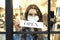 Woman in protective mask holding open sign in store window