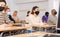 Woman in protective mask listening to lesson in extension school