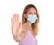 Woman in protective mask showing stop gesture on white background, focus on hand. Prevent spreading of coronavirus