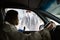 Woman in protective mask sitting in car and talking with medical worker