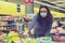 Woman in a protective mask in a supermarket chooses children`s toys. Woman in medical mask at the supermarket toned