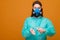 woman in protective medical equipment with antiseptic in hands medical mask on face on a yellow background, coronavirus pandemic