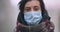 Woman in protective medical mask walking slowly on camera