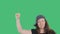 Woman protester with raised hand clenched in fist on green background. Female social revolution. National rebellion and