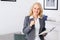 Woman psychologist portrait standing at casual home office holding paper holder