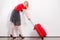 Woman pulling heavy red travel bag