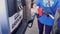 Woman pumping gasoline from self service gas pump