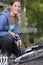 Woman pumping up bike outdoors