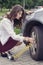Woman pumps up her car tire
