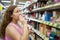 Woman purchaser smelling perfume in shop