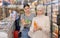 Woman purchasers choosing cool drink in big supermarket