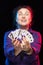 A woman in purple clothes holds a deck of cards and shows tricks