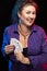 A woman in purple clothes holds a deck of cards and shows tricks