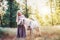Woman in purple dress hugging white unicorn horse. Dreams come true. Fairy tale