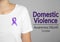 Woman with purple ribbon on background, closeup. Symbol of Domestic Violence Awareness