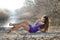 Woman in a purple short dress lying on dry reeds