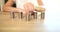 Woman pushes a wad of stacks of money coins forward on table