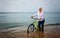 Woman pushing her bicycle through shallow surf