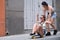 A woman pushing her friend from behind on a skateboard