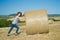 Woman pushing huge bales of hay