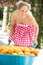 Woman Pushing Wheelbarrow Filled With Oranges