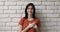 Woman put folded palms on heart, pose on wall background