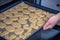 A woman puts a baking tray in the oven with Easter cookies for cooking