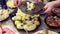 A woman puts boiled potatoes in a plate at the festive table. Many dishes on the table, homemade