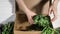 Woman puts bunches of fresh greenery into cardboard box