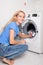 Woman puts clothes in the washing machine