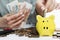 The woman puts coins in a piggy bank. Economical budget allocation. Selective focus