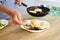 Woman puts food on plates. Homemade dinner for the whole family