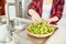 Woman puts green grapes in a wooden bowl