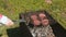 Woman puts a grill with chops on the brazier. Close-up hand.