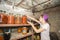 Woman puts jars with vegetables and fruits in the basement with food, for storage for a long time.