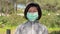 A woman puts on a mask to her face to protect against coronavirus, in the park after training. Spring allergy