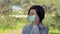 A woman puts on a mask to her face to protect against coronavirus, in the park after training. Spring allergy