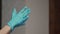 Woman puts on rubber gloves on hands on blurred background