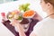 Woman puts vegetables into the pressure cooker.