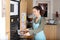 Woman putting a baking pan with chestnuts in oven