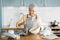 woman putting batter into baking molds on kitchen