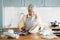 woman putting batter into baking molds on kitchen