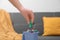 Woman putting battery into mini recycling bin indoors, closeup