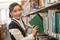 Woman putting book back onto a bookshelf