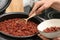 Woman putting brown rice into bowl from multi cooker in kitchen