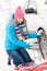 Woman putting chains on car winter tires